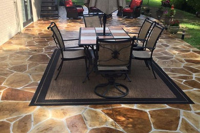 This is an example of a large classic back patio in Cincinnati with stamped concrete and no cover.