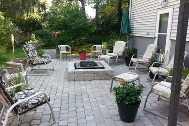 Inspiration for a mid-sized backyard concrete paver patio remodel in New York with a fire pit and no cover