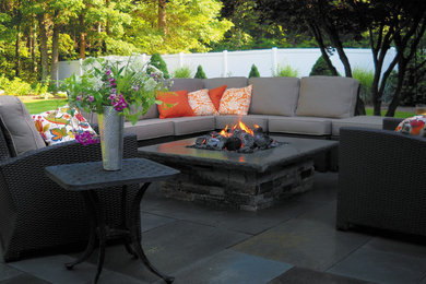Imagen de patio actual de tamaño medio sin cubierta en patio trasero con brasero y adoquines de piedra natural