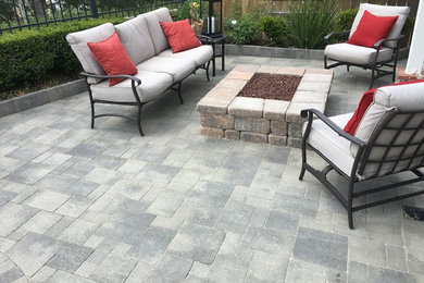Example of a mid-sized trendy backyard concrete paver patio design in Orange County with a fire pit and no cover