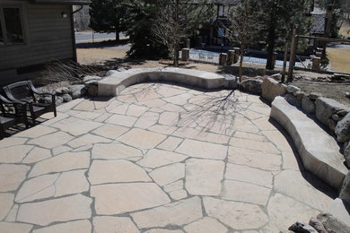 Inspiration for a mid-sized timeless backyard stone patio remodel in Denver with no cover