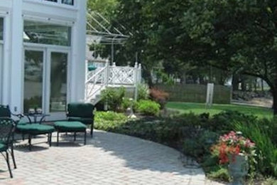 Diseño de patio de tamaño medio en patio trasero con adoquines de ladrillo
