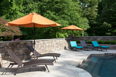 Example of a large arts and crafts backyard concrete paver patio container garden design in Charlotte with an awning