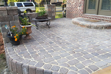 Inspiration for a mid-sized backyard stone patio remodel in Charlotte with a fire pit and no cover