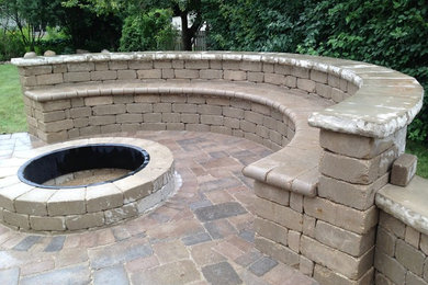 Medium sized traditional back patio in Chicago with a fire feature, natural stone paving and no cover.