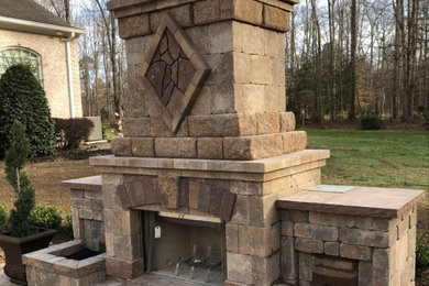 Example of a large backyard brick patio design in Richmond with a fireplace