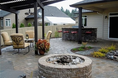 Modelo de patio clásico renovado de tamaño medio en patio trasero con adoquines de piedra natural y pérgola