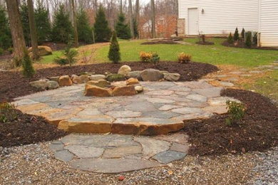 Inspiration for a mid-sized backyard stone patio remodel in Cleveland with no cover
