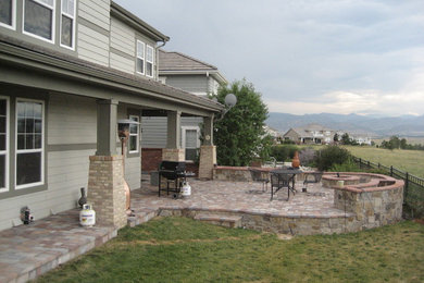 Inspiration for a mid-sized backyard brick patio remodel in Denver with a fire pit