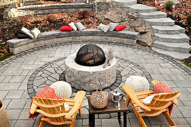 Inspiration for a mid-sized backyard stamped concrete patio remodel in Toronto with a fire pit and no cover