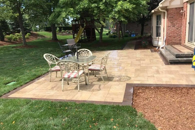 Example of a mid-sized minimalist backyard brick patio design in Detroit with no cover