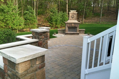Inspiration for a large backyard brick patio remodel in Grand Rapids with a fire pit and no cover