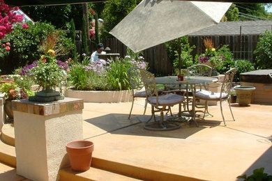 Foto de patio tradicional de tamaño medio sin cubierta en patio trasero con fuente y losas de hormigón