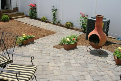 Design ideas for a medium sized traditional back patio in Charlotte with a fire feature and brick paving.