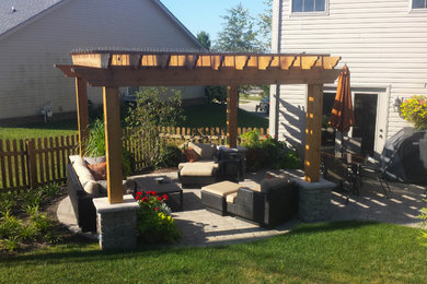 This is an example of a medium sized traditional back patio in Other with concrete paving and a pergola.