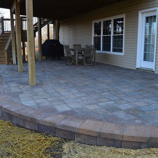 Idee per un piccolo patio o portico stile americano dietro casa con pavimentazioni in cemento e un tetto a sbalzo