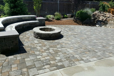 Photo of a large traditional back patio in Boise with a fire feature, natural stone paving and no cover.