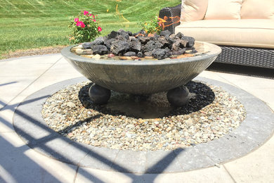 Paver patio with a pergola and fire/water feature.