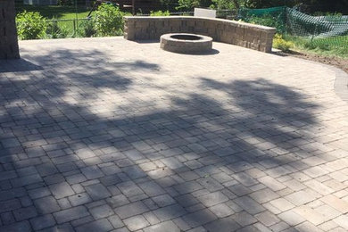 Medium sized classic back patio in Omaha with a fire feature and brick paving.