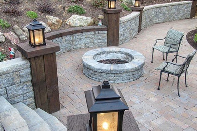 Large elegant backyard stone patio photo in Charlotte with a fire pit and no cover