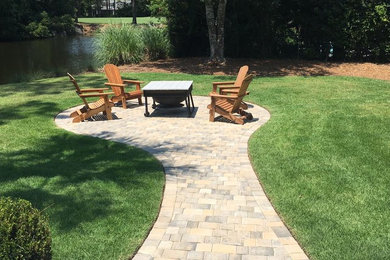 Inspiration for a small timeless backyard brick patio remodel in Jacksonville with a fire pit and no cover