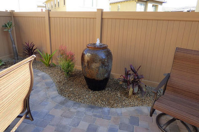Inspiration for a medium sized back patio in Orange County with a water feature and no cover.