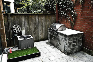 Diseño de patio minimalista de tamaño medio sin cubierta en patio trasero con cocina exterior y adoquines de hormigón