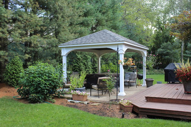 Example of a large transitional backyard stone patio kitchen design in Boston with a gazebo
