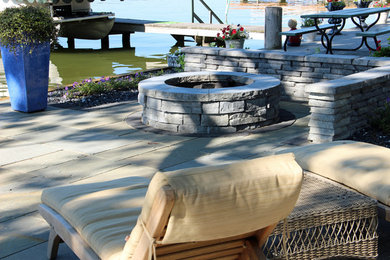 Imagen de patio contemporáneo de tamaño medio sin cubierta en patio trasero con brasero y adoquines de piedra natural