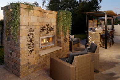 Example of a mid-sized transitional backyard concrete paver patio kitchen design in Boise with a pergola