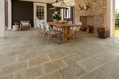 Example of a mid-sized cottage backyard concrete paver patio design in Houston with a fire pit and a roof extension