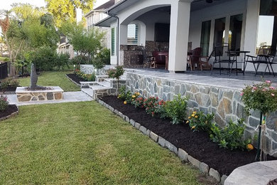 Inspiration for a medium sized contemporary back patio in Houston with a potted garden, natural stone paving and a roof extension.