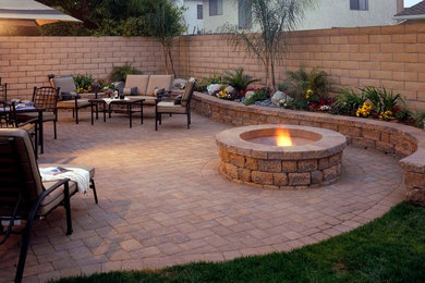 Inspiration for a mid-sized rustic courtyard concrete paver patio remodel in Other with a fire pit