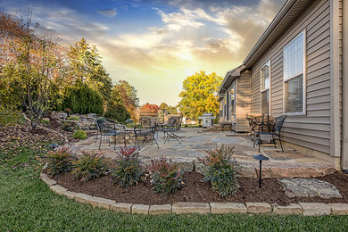 Mid-sized elegant backyard stone patio fountain photo in St Louis