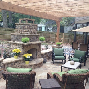Esempio di un grande patio o portico chic dietro casa con una pergola e pavimentazioni in pietra naturale