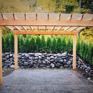Pergola covered patio with retaining wall and plant screening