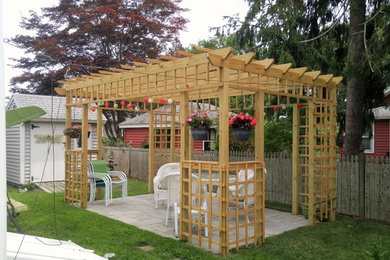 Diseño de patio minimalista de tamaño medio en patio trasero con adoquines de hormigón y pérgola