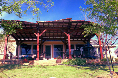 Example of a large farmhouse backyard patio design in Dallas with a pergola