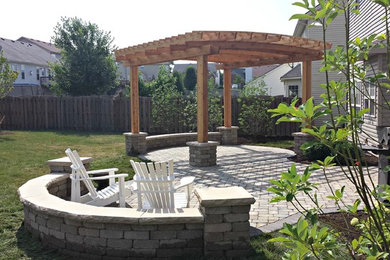 Immagine di un patio o portico chic di medie dimensioni e dietro casa con un focolare, pavimentazioni in cemento e una pergola