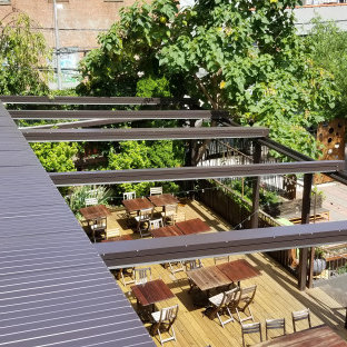 Ispirazione per un grande patio o portico industriale in cortile con pedane e una pergola