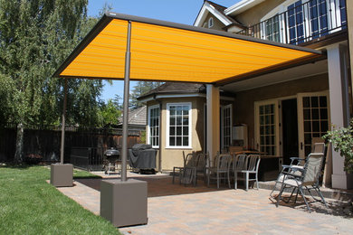 Inspiration for a medium sized modern back patio in San Francisco with brick paving and a pergola.