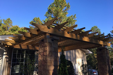 Patio - mid-sized traditional backyard stone patio idea in Raleigh with a pergola