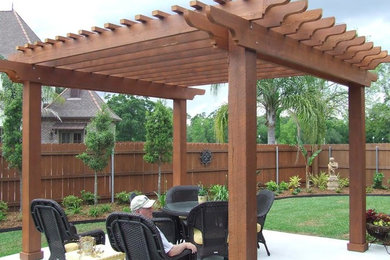Inspiration for a large timeless backyard concrete patio kitchen remodel in New Orleans with a pergola