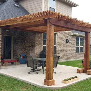 Ispirazione per un piccolo patio o portico american style dietro casa con lastre di cemento e una pergola