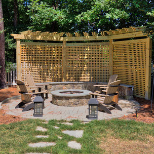 Esempio di un patio o portico classico di medie dimensioni e dietro casa con pavimentazioni in pietra naturale, una pergola e un focolare