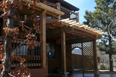 Ejemplo de patio rústico extra grande en patio trasero con pérgola y adoquines de hormigón