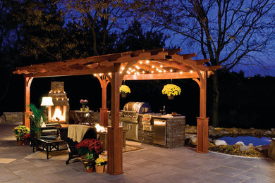 Imagen de patio tradicional de tamaño medio en patio trasero con brasero, adoquines de piedra natural y pérgola