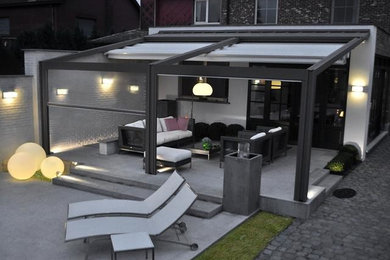 Diseño de patio moderno en patio trasero con pérgola