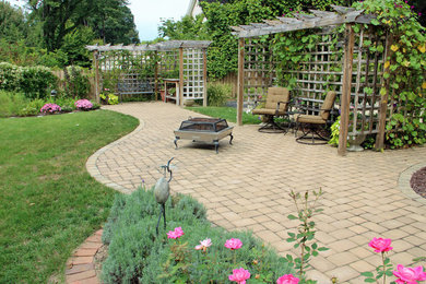 Diseño de patio clásico de tamaño medio en patio trasero con adoquines de hormigón y pérgola