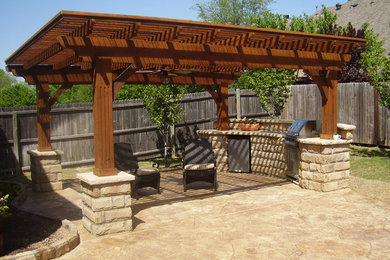 Diseño de patio de tamaño medio en patio trasero con cocina exterior, adoquines de hormigón y pérgola